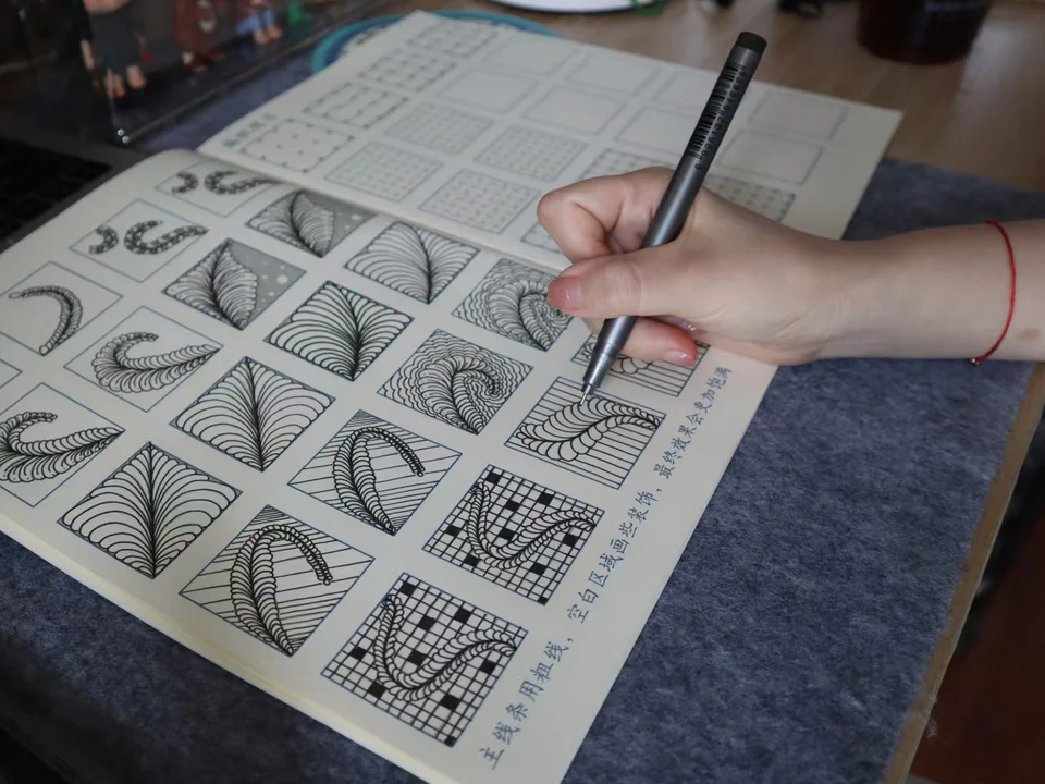 二月正在纸上完成连续叶片与纹样的控笔练习